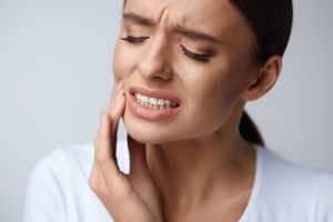 A lady experiencing a TMJ pain